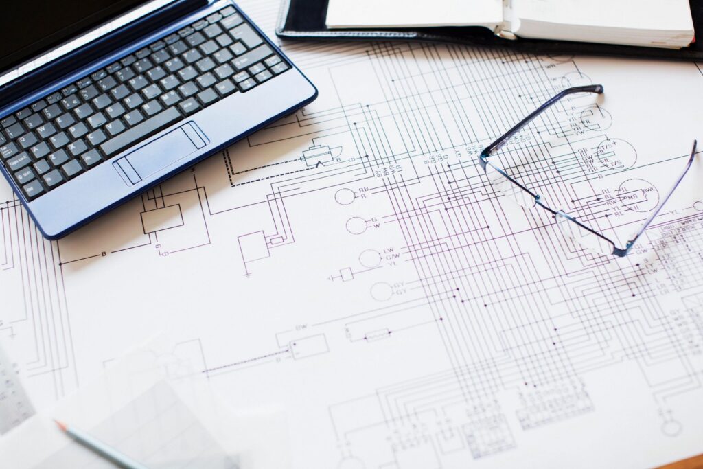Blueprint, laptop and eyeglasses in office